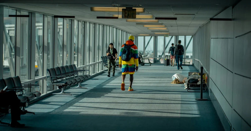 Traveller walking to the gate with a carry-on backpack in an airport corridor